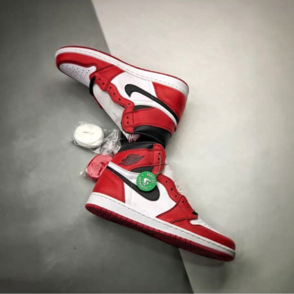 Red and white high-top sneakers on a gray surface with a Shopify website URL in the background.