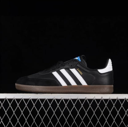Black Adidas shoes with white stripes on a black background