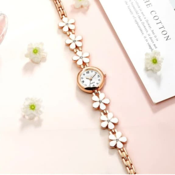 Rose gold bracelet with floral designs on a light pink background